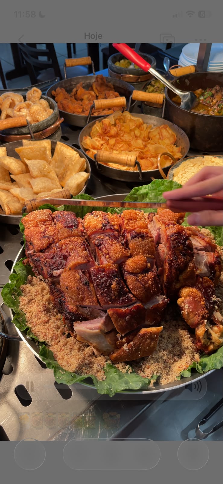 Pernil assado com pele crocante sobre farofa, servido no buffet